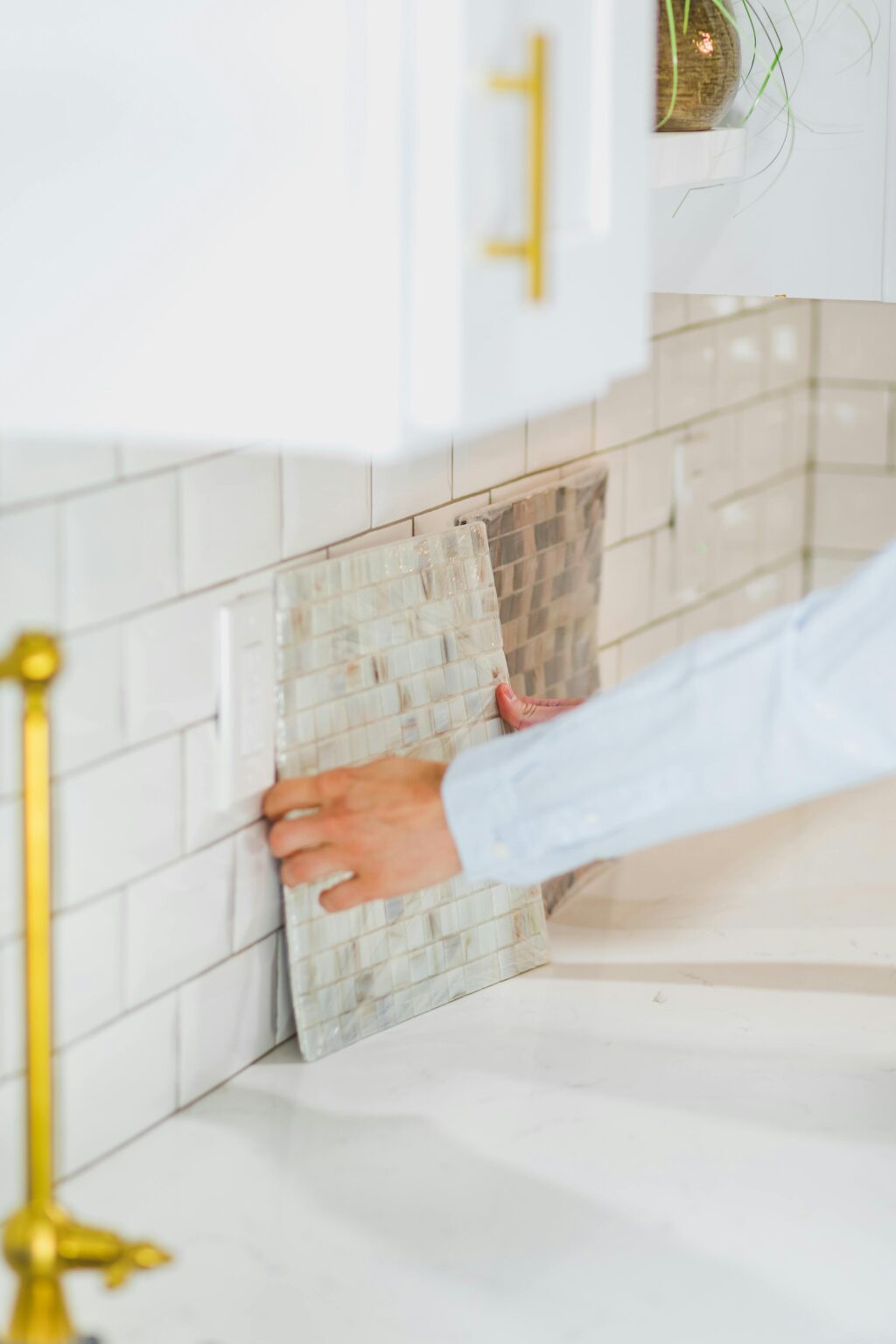 Comparing a mosaic tile sample with a kitchen tile wall